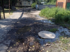 Едкий запах канализации, усиленный летним пеклом, стоит в переулке Мостовой в Шахтах