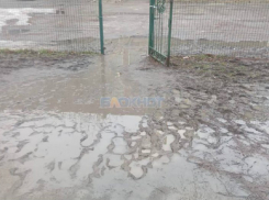 У входа в школу №22 в  Шахтах родители учеников вынуждены переносить детей через лужи и грязь