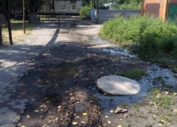 Едкий запах канализации, усиленный летним пеклом, стоит в переулке Мостовой в Шахтах