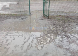 У входа в школу №22 в  Шахтах родители учеников вынуждены переносить детей через лужи и грязь