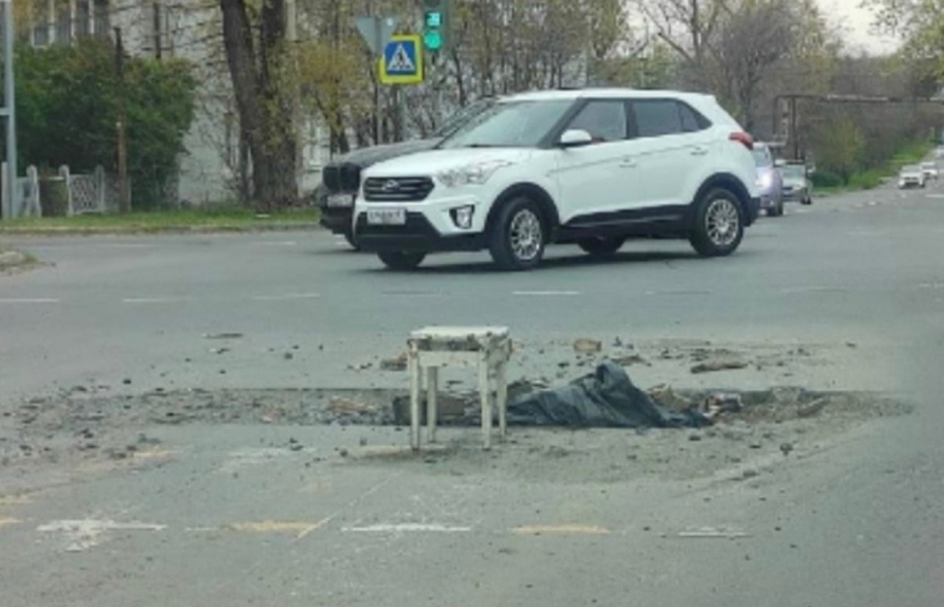 Яму на дороге в центре Шахт просто закидали мусором и поставили рядом табуретку